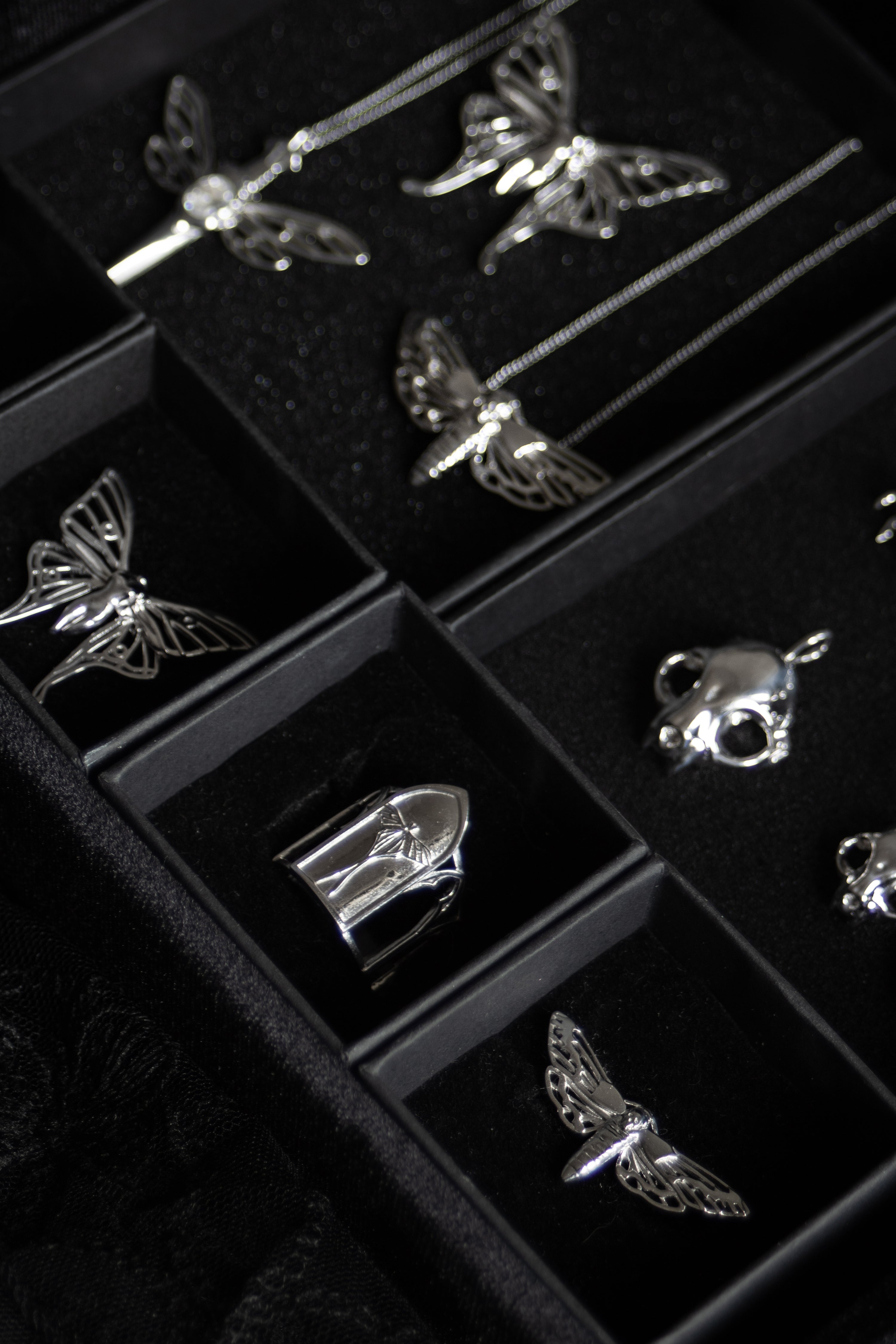 Gothic jewelry from The Specter’s Cabinet collection featuring silver Luna moth, cathedral, and cat skull designs by Anna Reikher