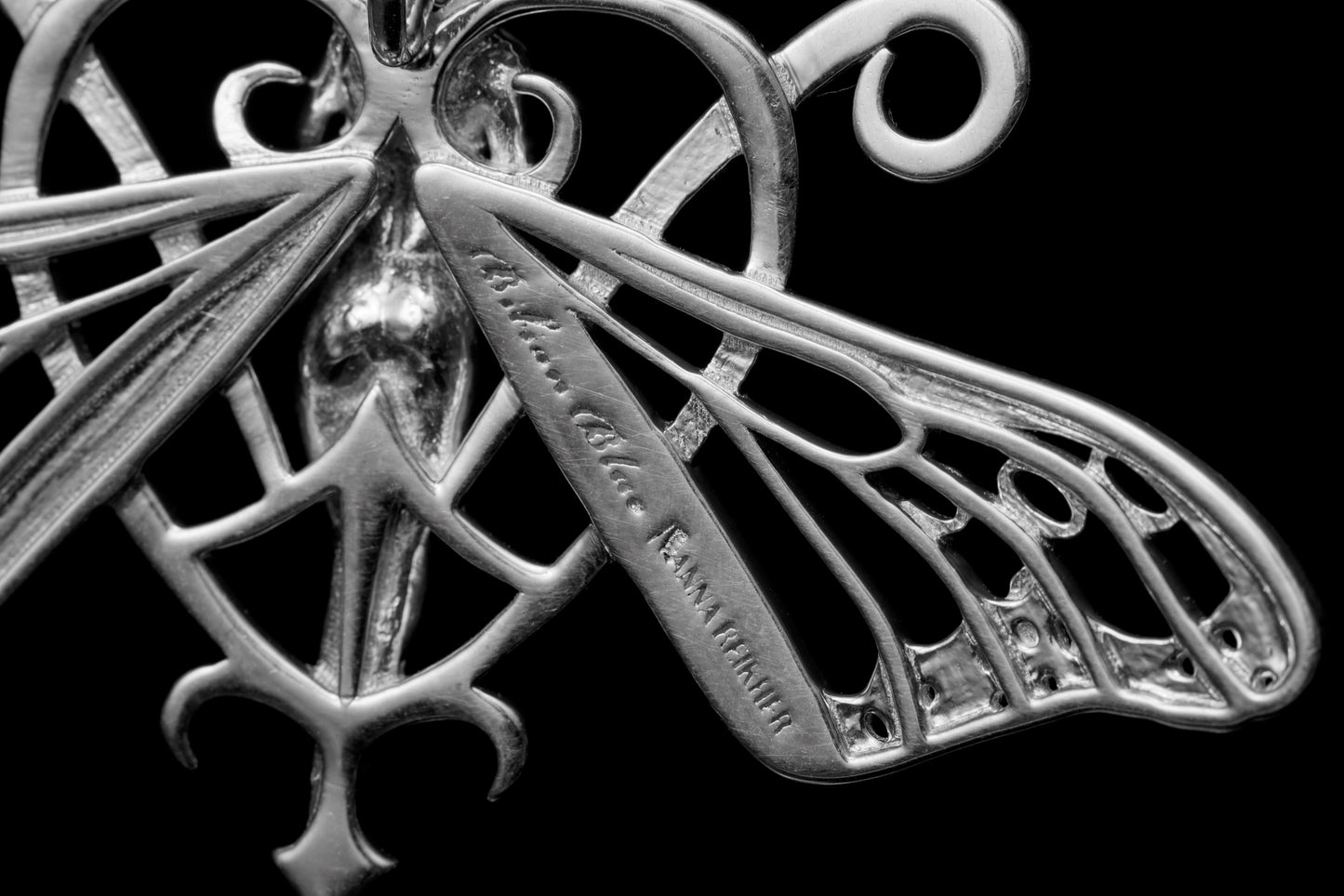 Close-up showing detailed silverwork on Art Nouveau butterfly earrings