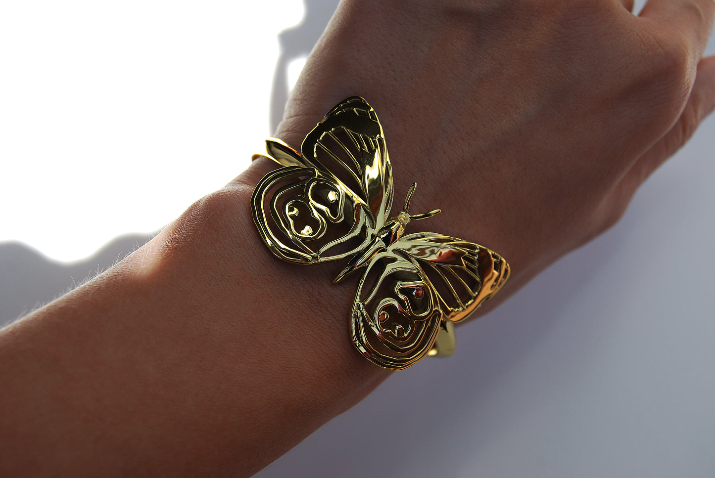 Eighty-eight Butterfly Bracelet in 14K gold plated finish worn on hand, emphasizing radiant polish and craftsmanship.