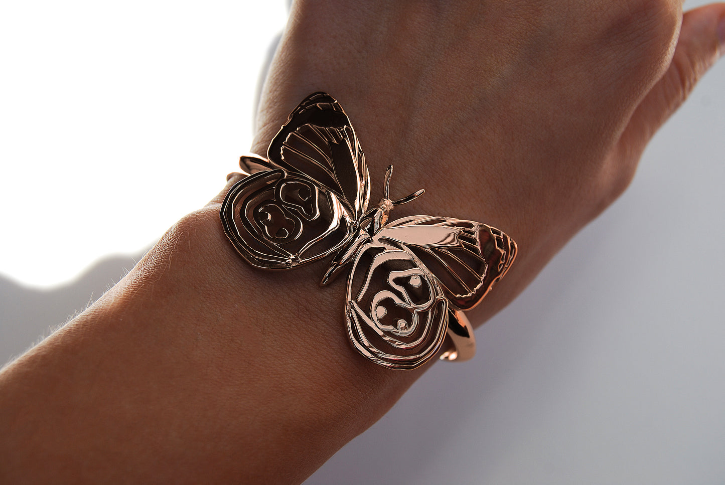 Eighty-eight Butterfly Bracelet in 14K rose gold finish worn on hand, highlighting warm tones and sculptural detail.