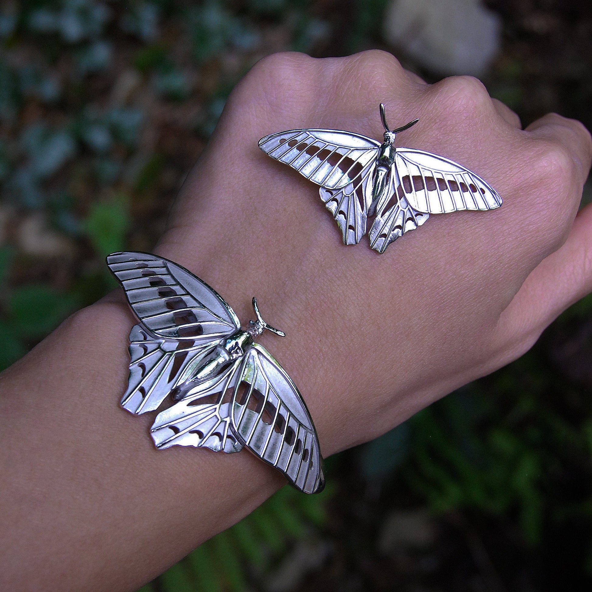 Blue Triangle Butterfly pendant and bracelet worn on hand, showcasing intricate insect jewelry design and silver craftsmanship.