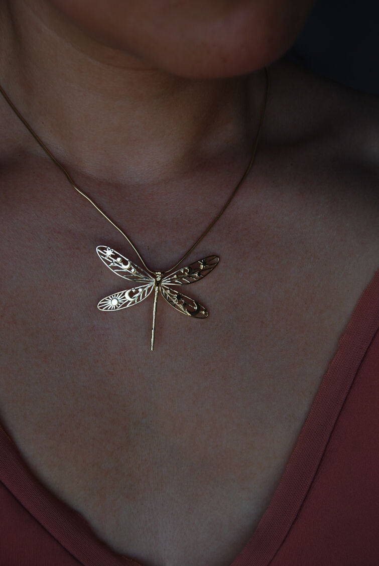 Lifestyle shot of model styling gold damselfly pendant necklace