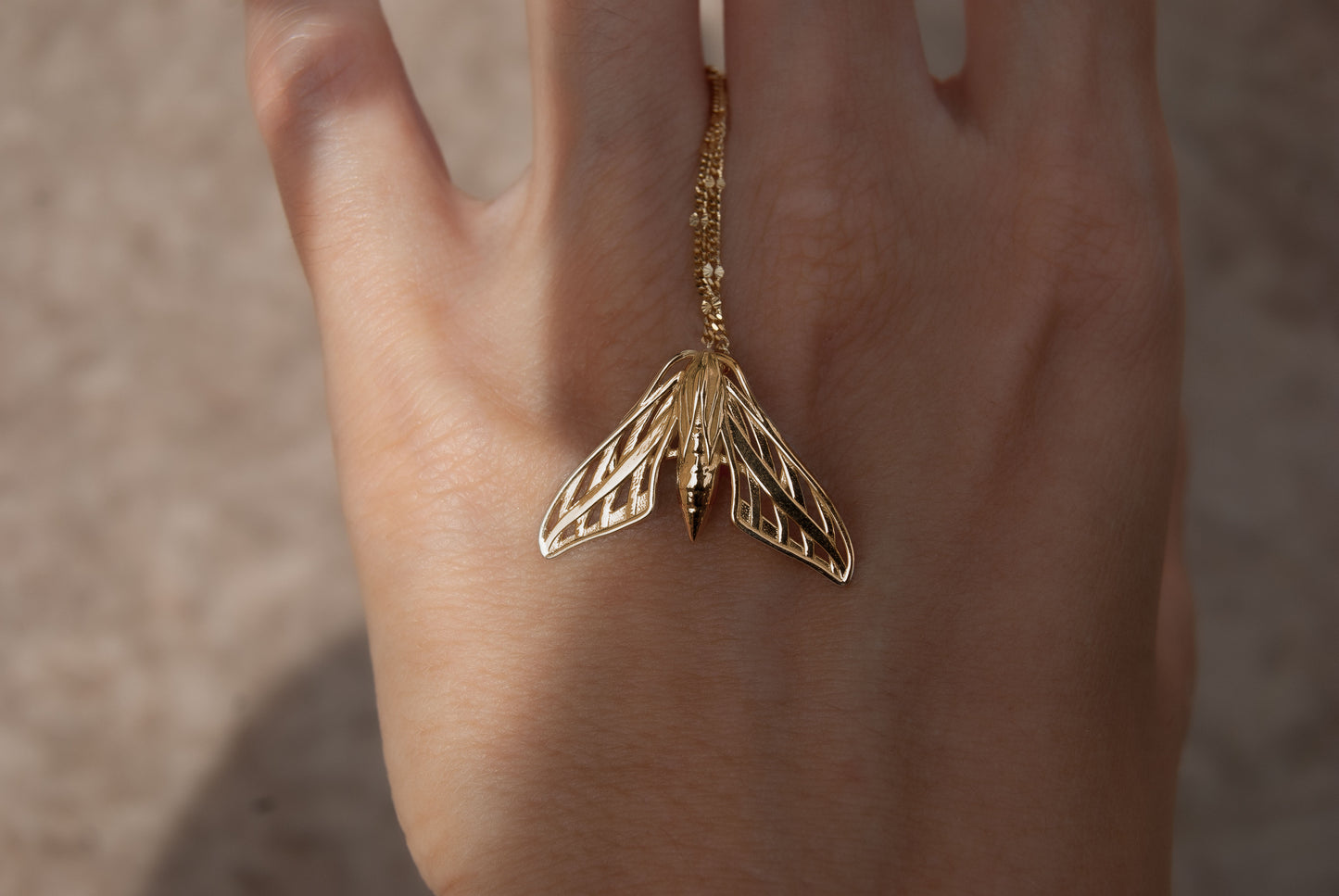 gold moth pendant necklace with deliicate patterns