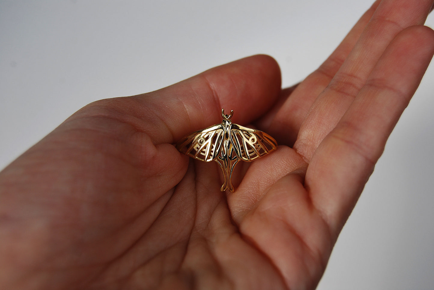 Close-up of the gold Luna Moth Ring, revealing fine detail in the wing pattern and polished finish.