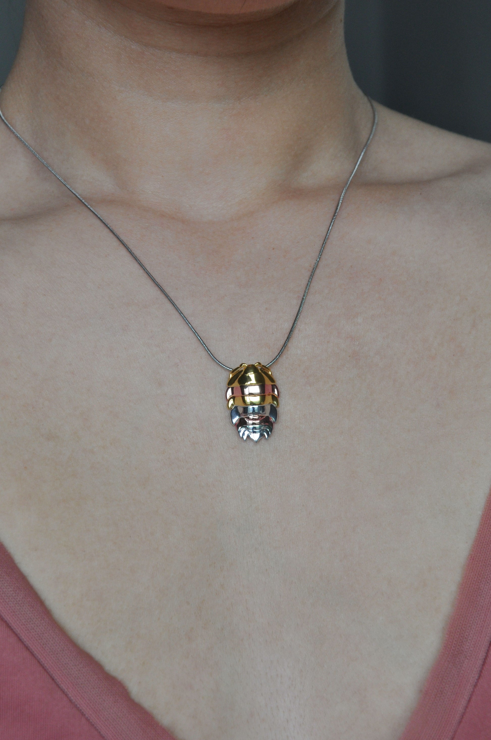 Mixed metal isopod pendant with intricate detailing and colorful enamel, perfect for nature-inspired insect jewelry lovers