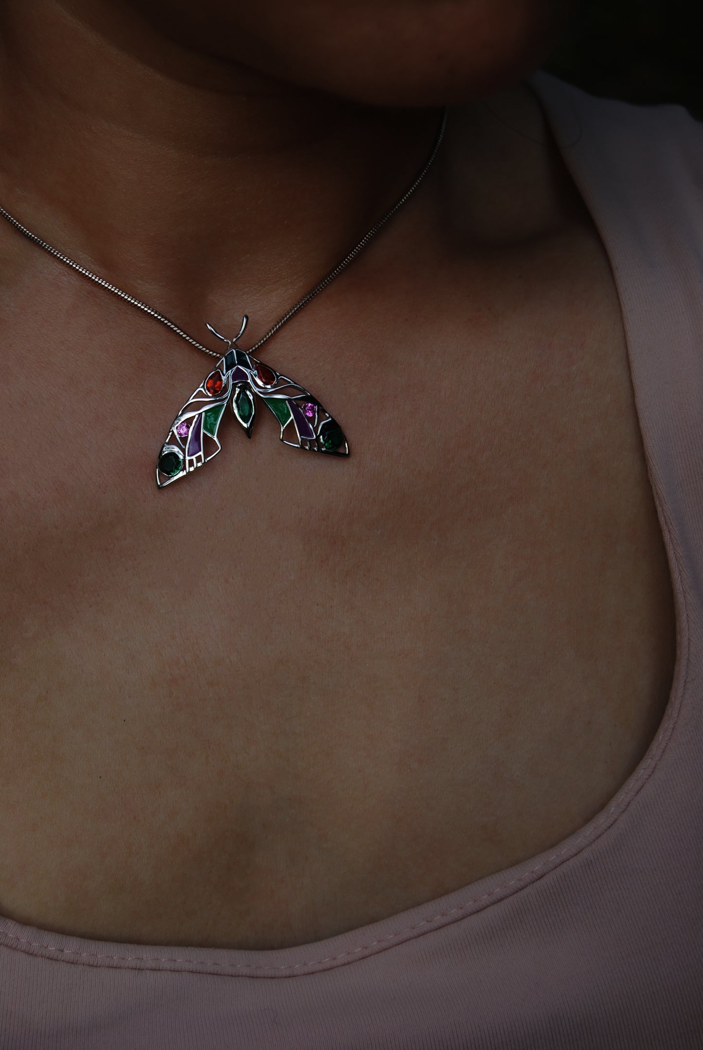 Model wearing silver moth pendant necklace