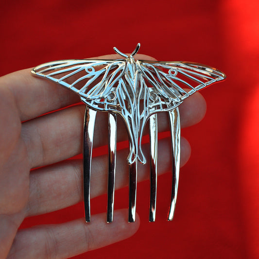 Front view of a rhodium-plated silver Luna Moth hair comb featuring intricate cut-out wings and nature-inspired insect jewelry design.