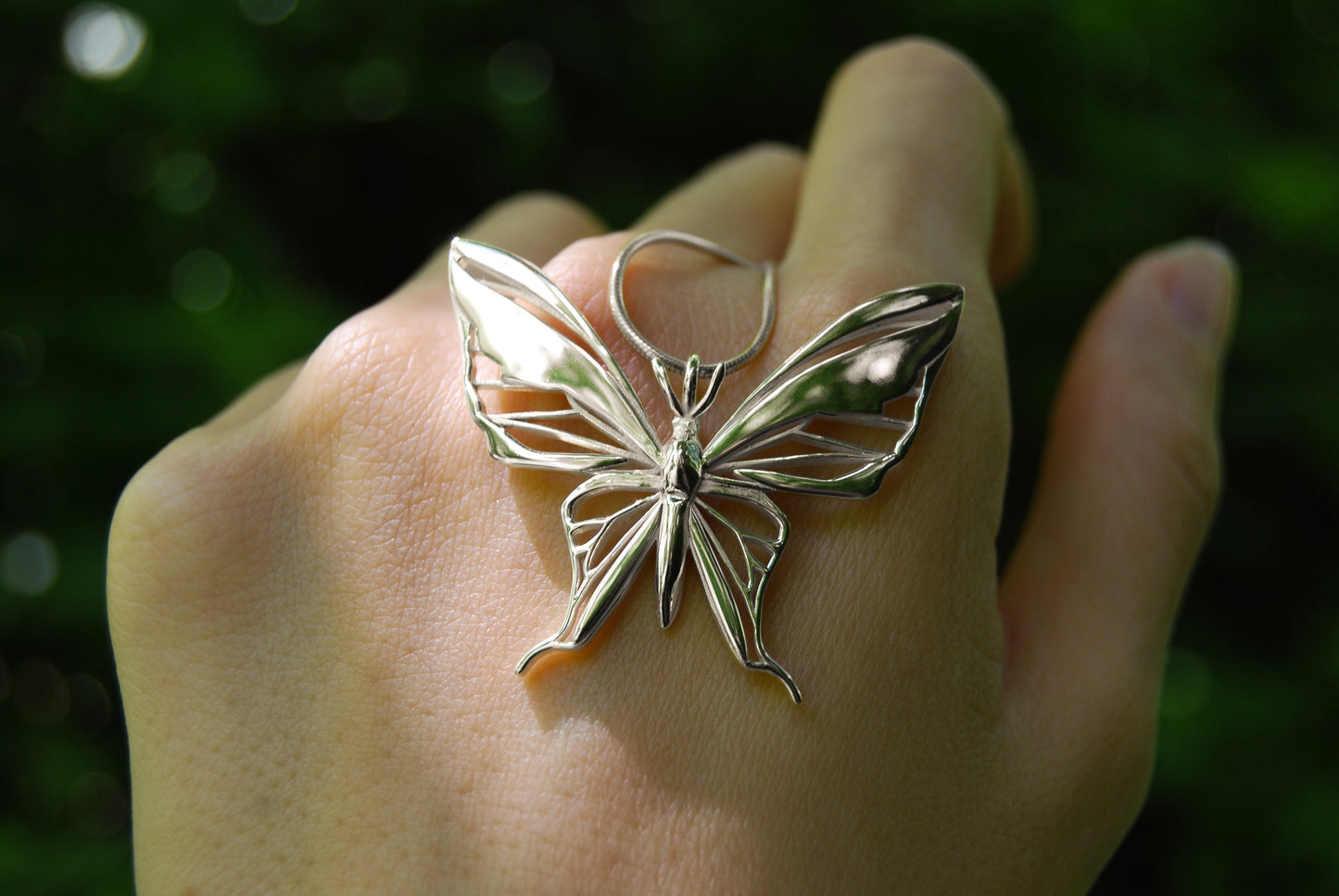 Sterling silver butterfly pendant necklace outdoors in natural setting