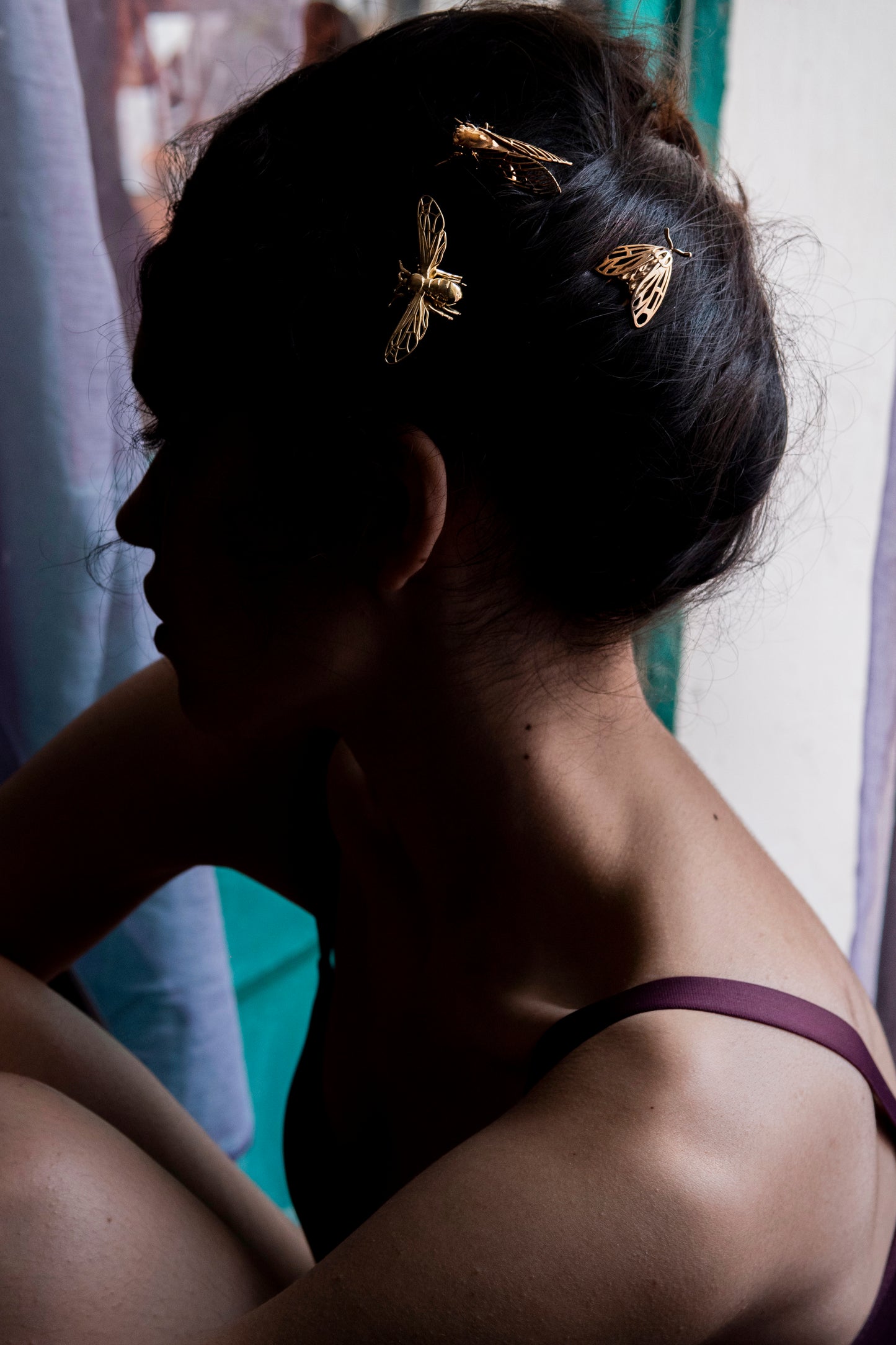 Model wearing bronze Tiger Moth, Cicada, and Bee hair pins styled in an elegant updo, showcasing handcrafted insect-inspired jewelry with warm metallic tones and detailed wing designs.