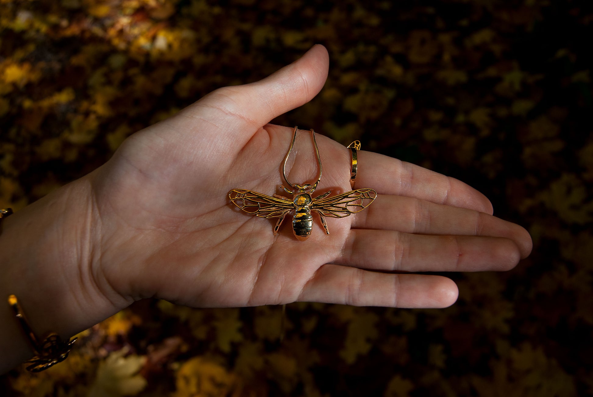 Artisan handmade bee pendant necklace showcased on a natural background