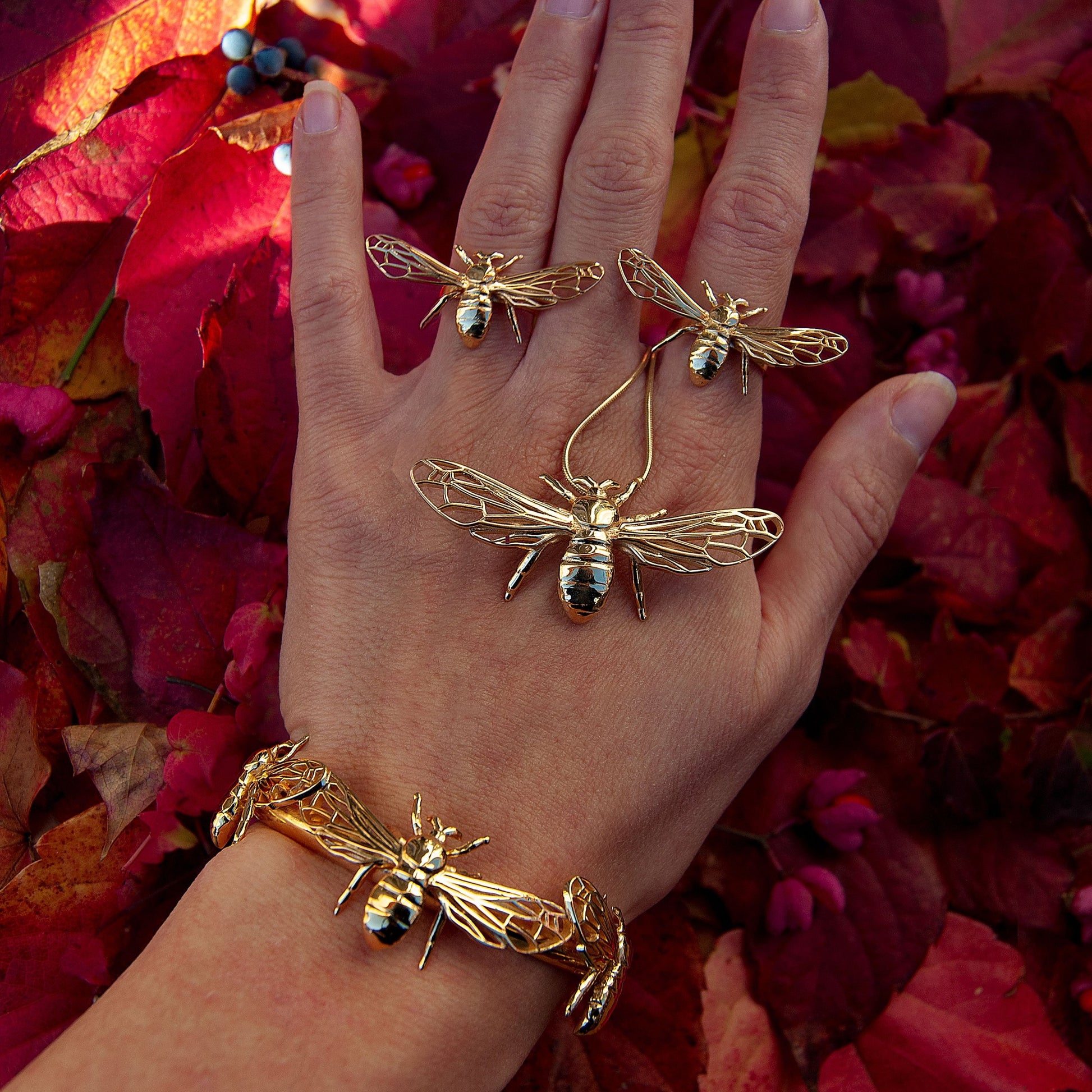 Model wearing silver and gold bee pendant necklace, front view