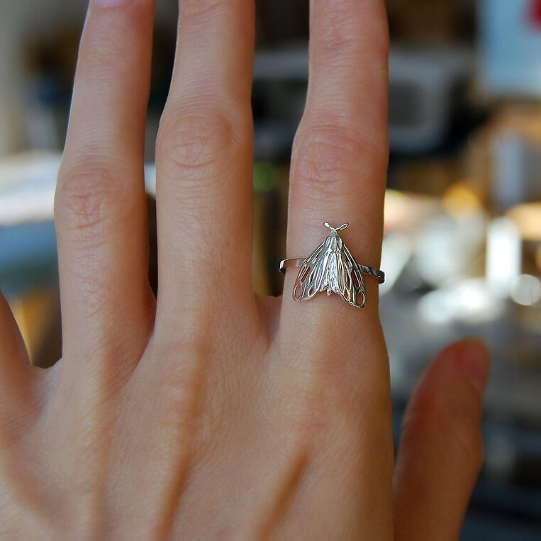 Closeup of sterling silver Tiger Moth Ring, showing folded wings and fine detailing.