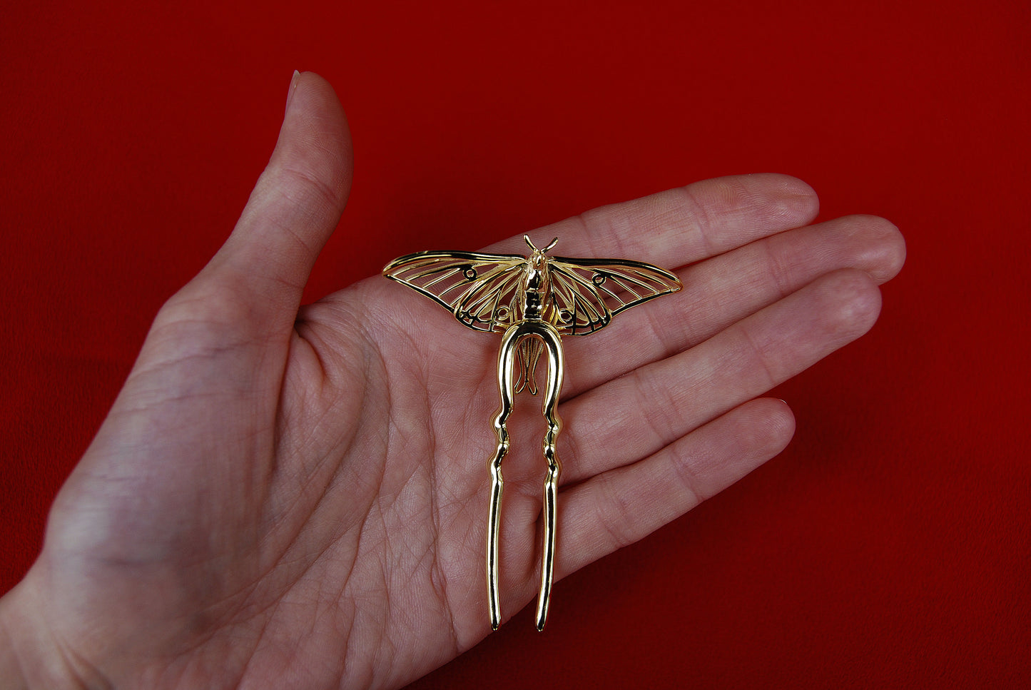 Back view of gold Luna Moth hair pin showing clasp mechanism and structural detailing, highlighting craftsmanship and functional design of insect-inspired jewelry.