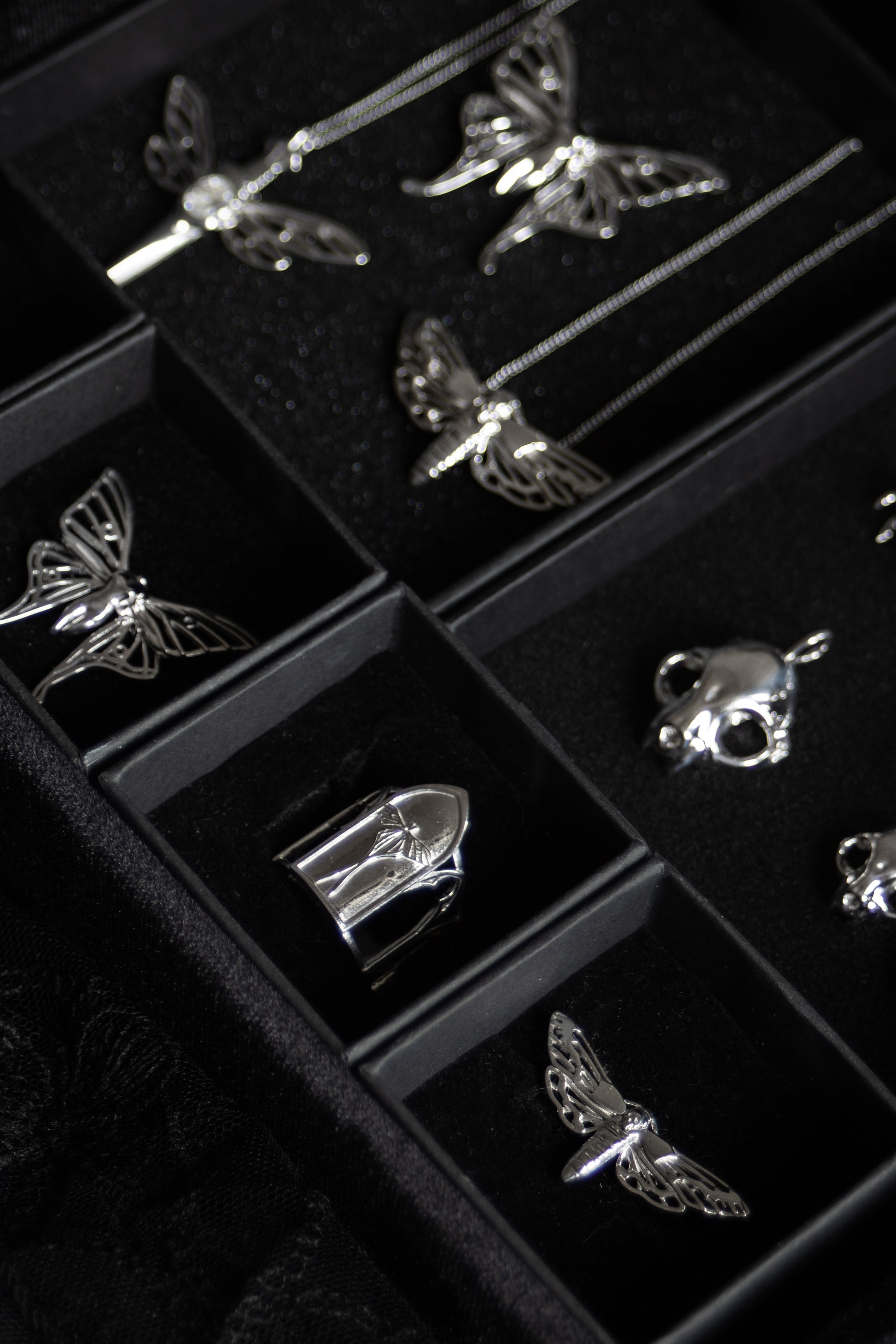 Gothic jewelry from The Specter’s Cabinet collection featuring silver Luna moth, cathedral, and cat skull designs by Anna Reikher