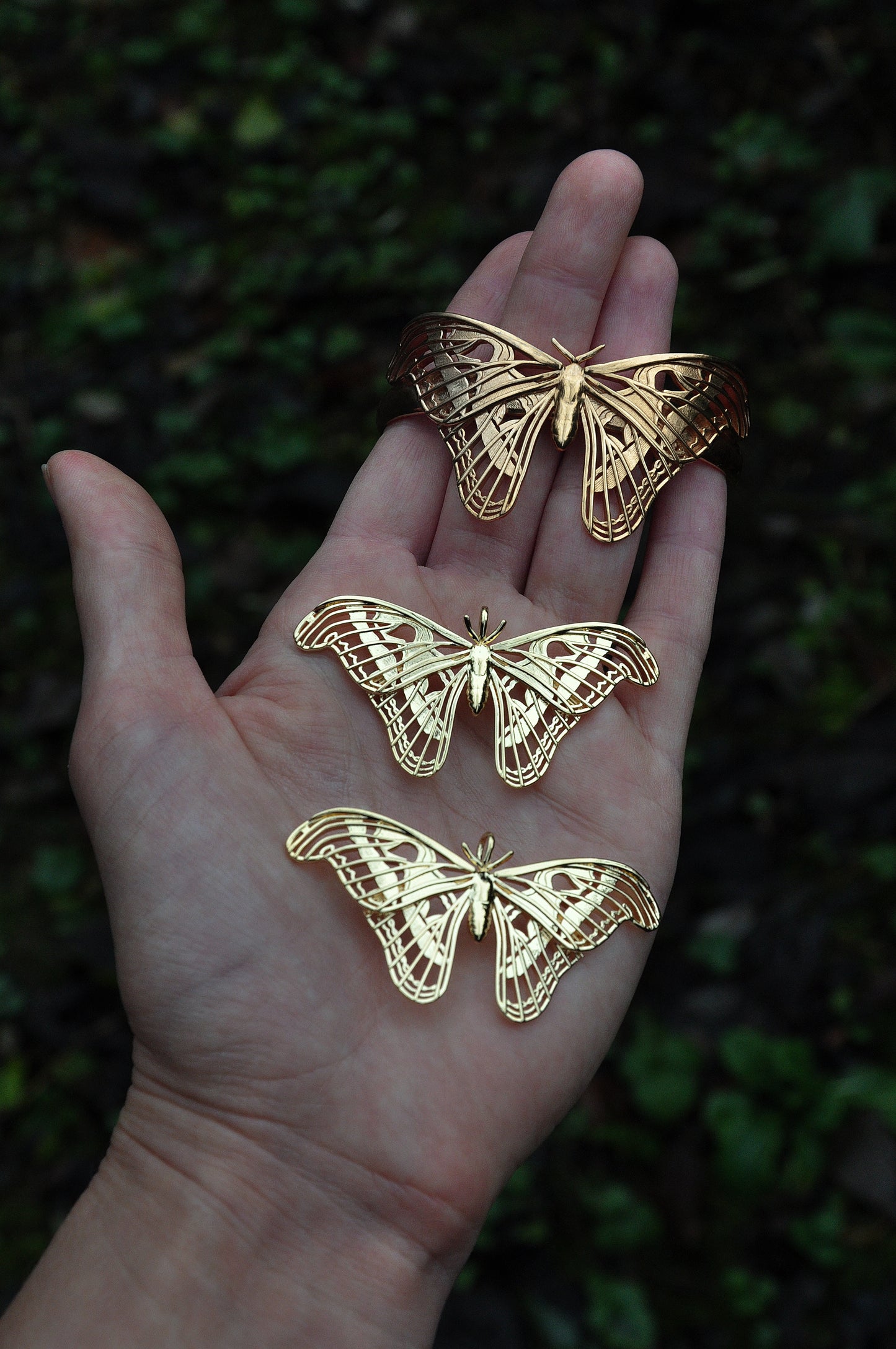 Another version of Atlas Moth jewelry in 14K gold plated finish, worn on hand with subtle texture detail.