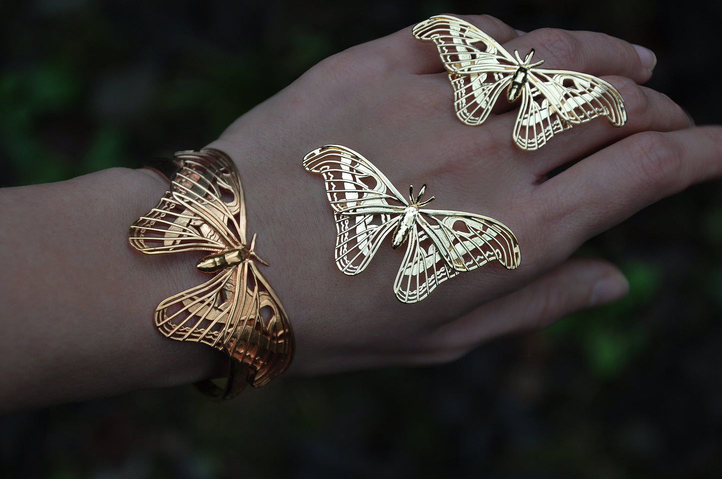 Atlas Moth Pendant and Bracelet in gold, styled on hand with focus on wing cut-outs and shine.