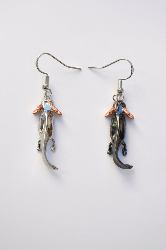 Front view of the mismatched Axolotl Drop Earrings on a white background — one in sterling silver, the other in black rhodium-plated silver, both with rose gold-plated gills.