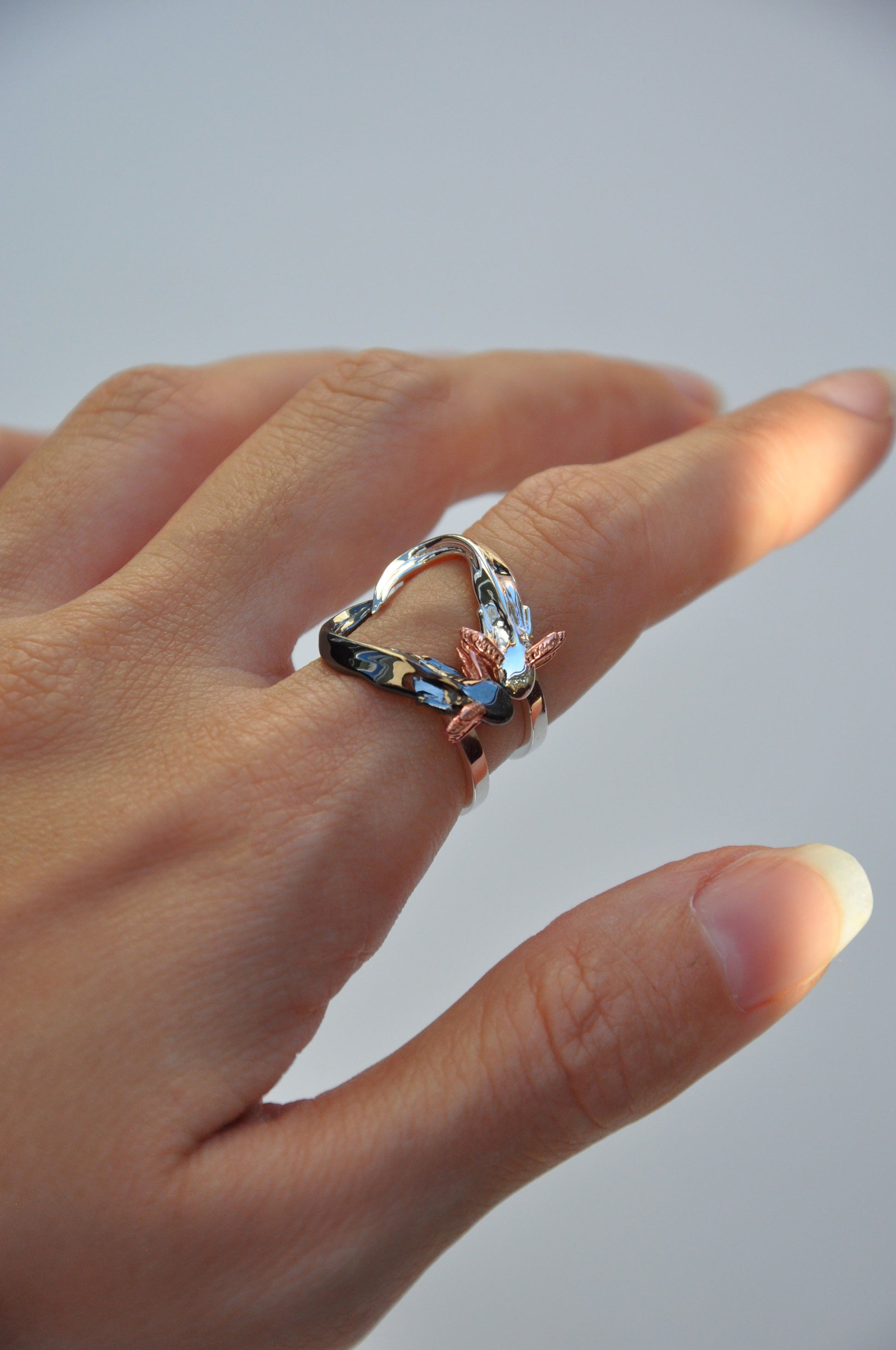 Horizontal display of Axolotl Ring Set showing contrast between polished silver and black rhodium axolotls, accented with rose gold gills.