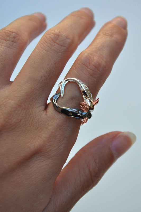 Front view of handcrafted Axolotl Stacking Ring Set forming a heart shape with tails — sterling silver and black rhodium axolotls with 14k rose gold gills.
