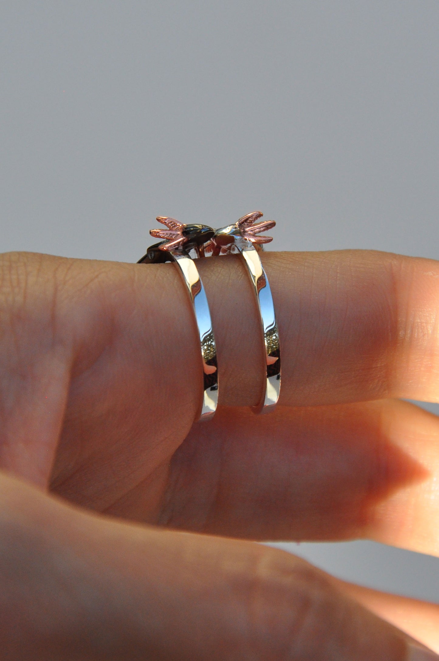 Side profile of Axolotl Stacking Rings showing sculptural details and rose gold gills — the axolotls appear lovingly intertwined, as if sharing a sweet moment together.