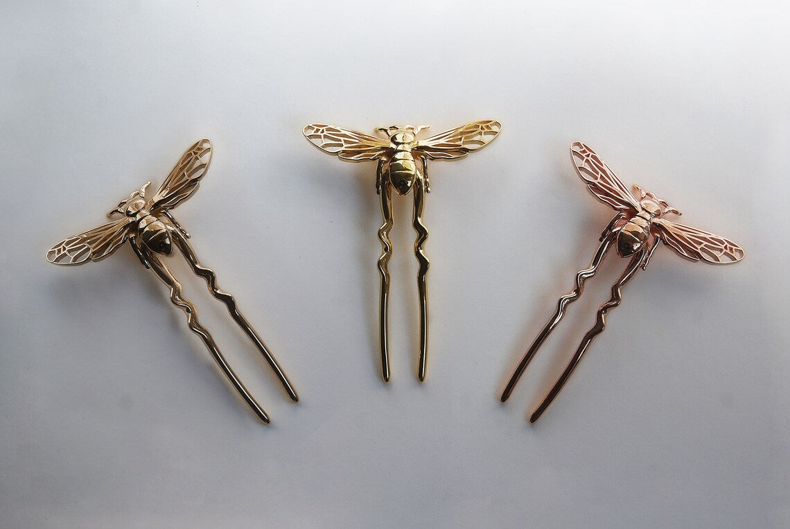Gold, bronze, and rose gold bee hair pins arranged on a white background, showcasing handcrafted insect-inspired jewelry in elegant metallic finishes.