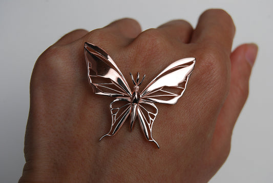Rose gold butterfly pendant necklace on white background
