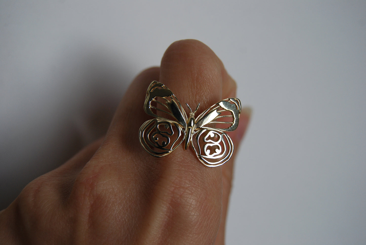 Close-up of butterfly ring worn on finger, highlighting sculptural wings and nature-inspired elegance.