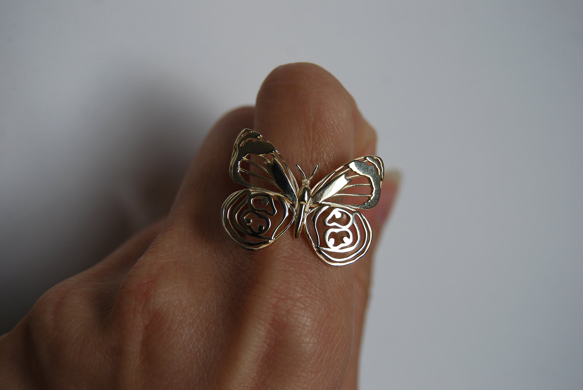 Close-up of butterfly ring worn on finger, highlighting sculptural wings and nature-inspired elegance.