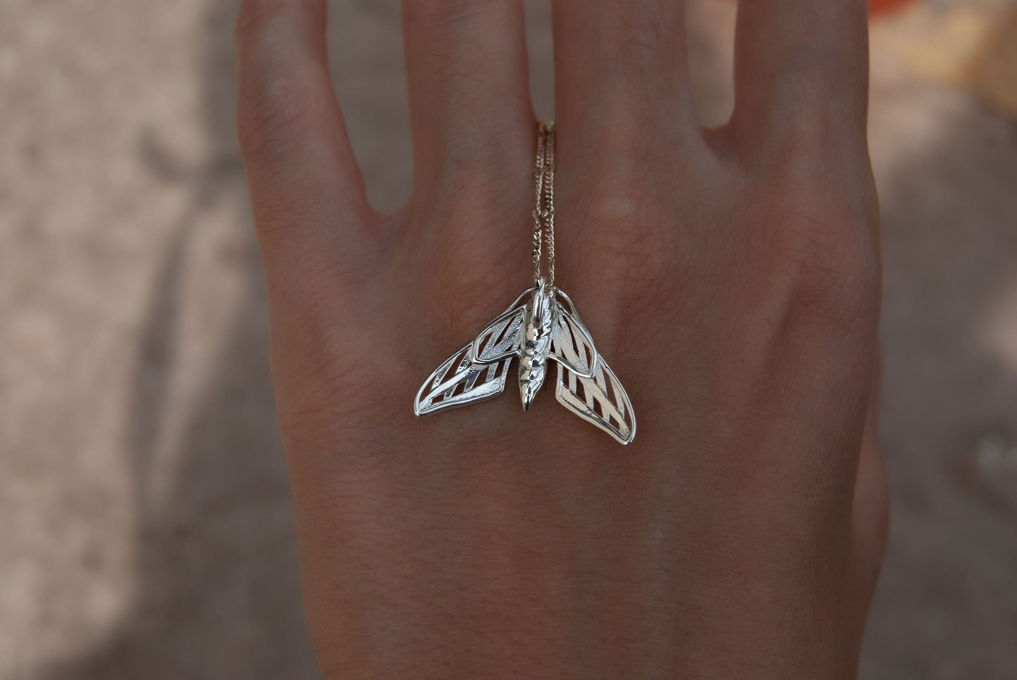 Silver death moth necklace with detailed wing patterns