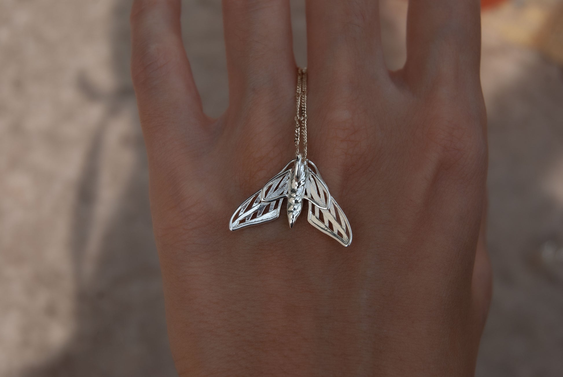 Silver death moth necklace with detailed wing patterns