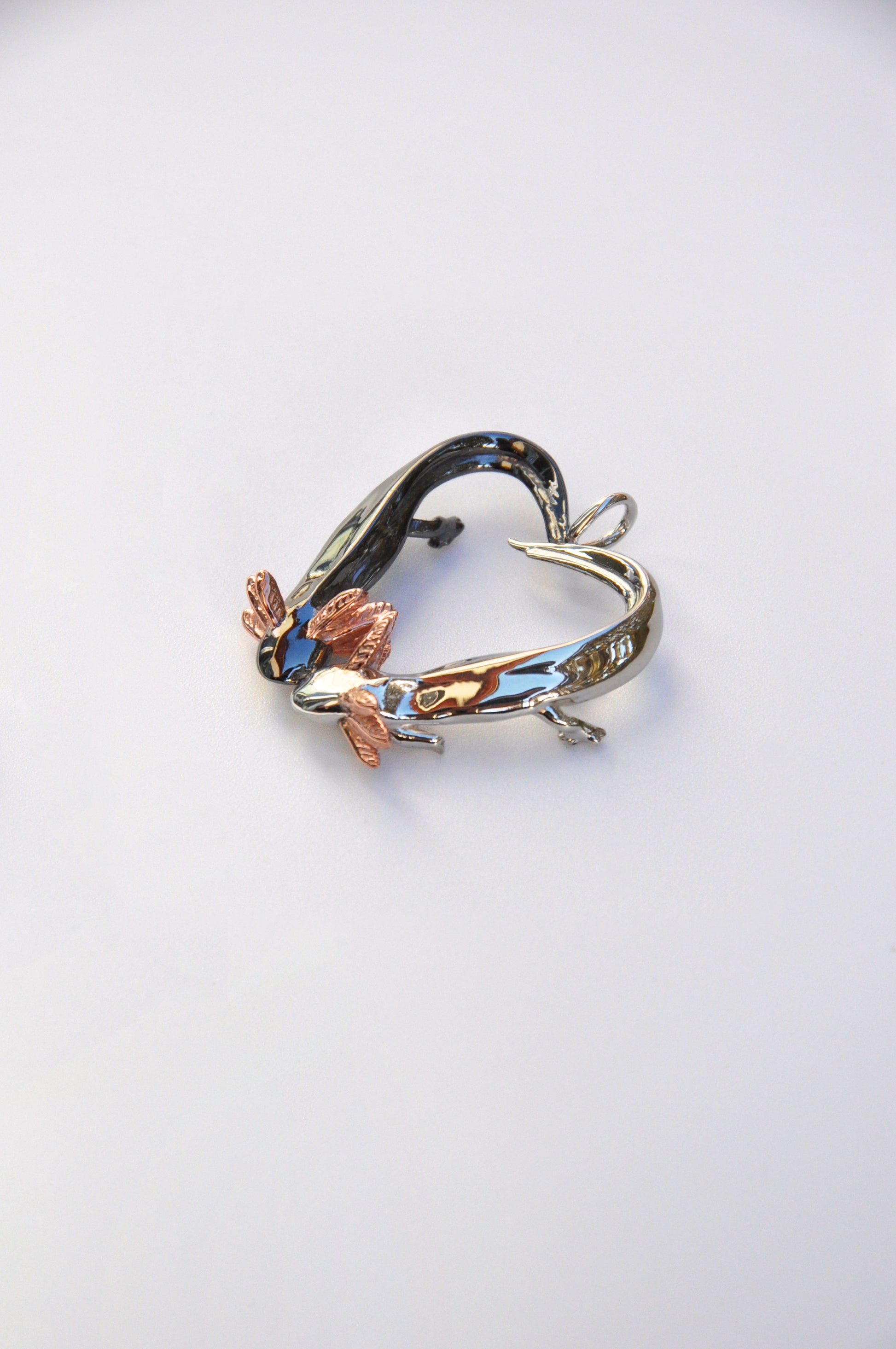 Side profile of the Exolotl Love Pendant on a white background, revealing the layered design and contrast between the two axolotls.