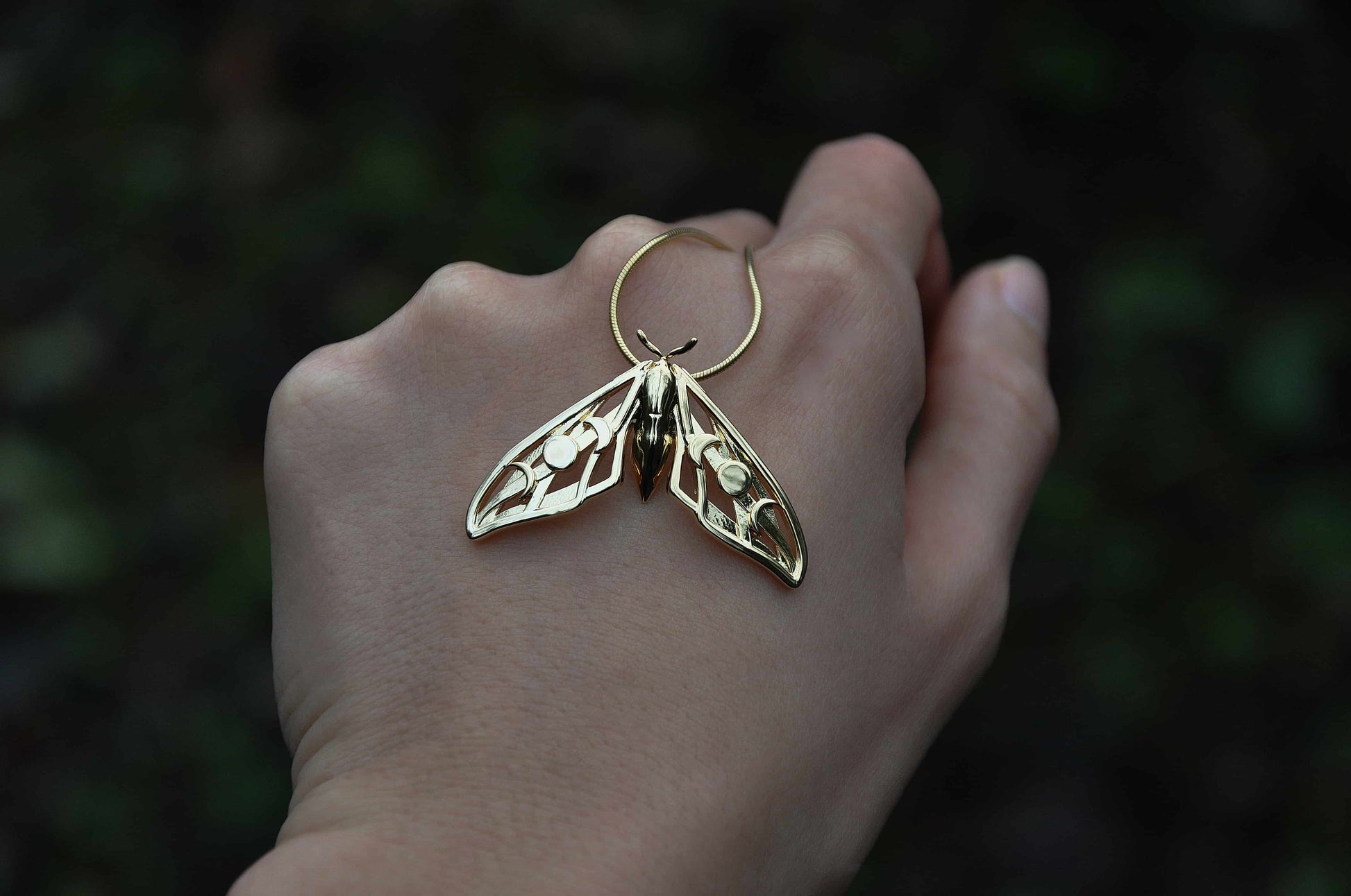Front view of the Elestial Hawk Moth Pendant in polished gold, highlighting lunar motifs and intricate craftsmanship.