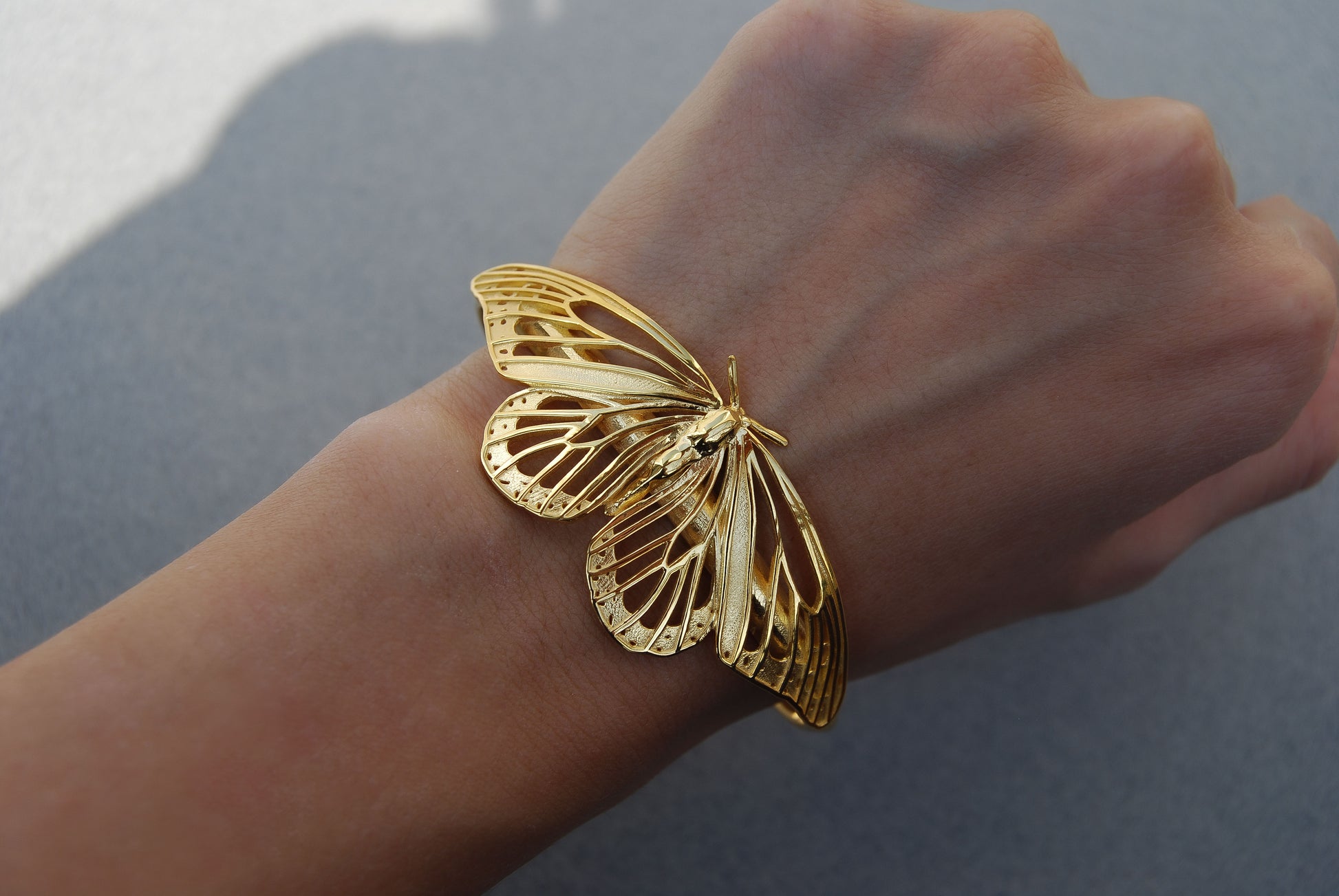14K gold-plated Monarch Butterfly Bracelet worn on hand, highlighting handcrafted detail and nature-inspired elegance.
