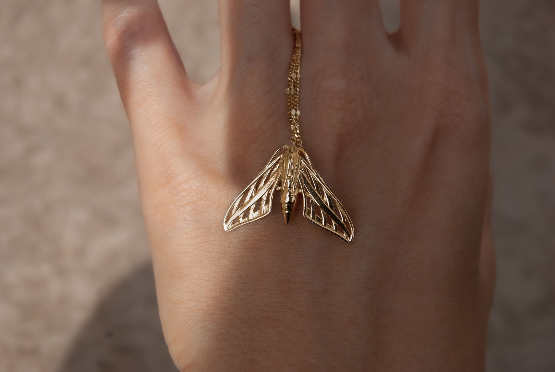 gold moth pendant necklace with deliicate patterns