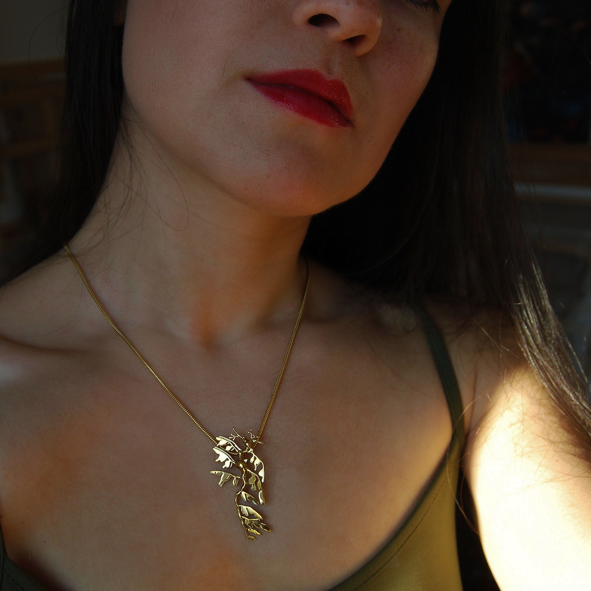 Model wearing 14K gold plated Leafy Sea Dragon Pendant, elegant sea creature jewelry.