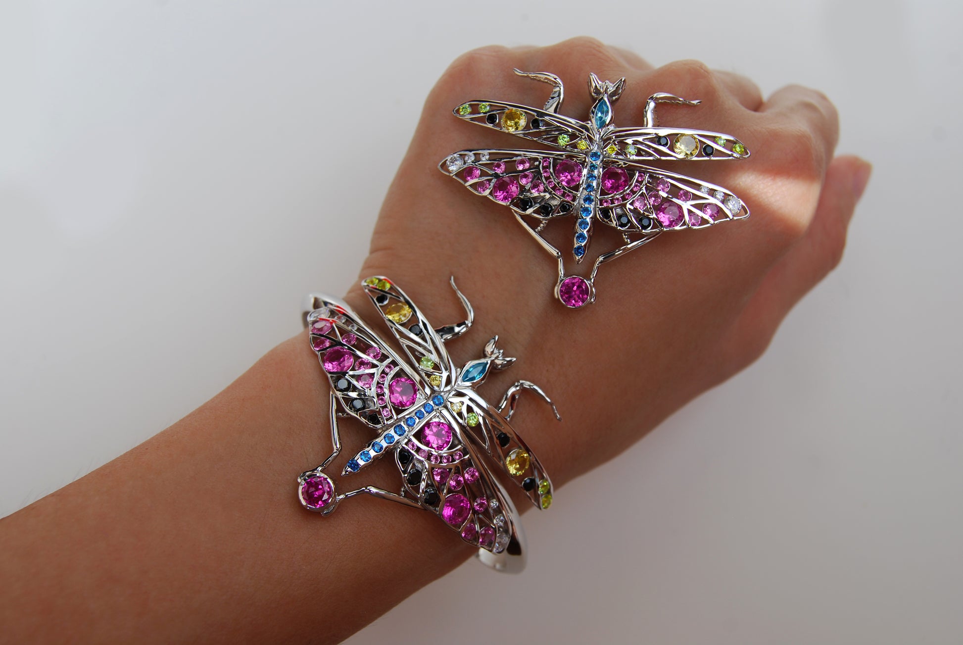 Sterling silver mantis pendant and bracelet with enamel and zirconia stones shown on hand over clean white backdrop