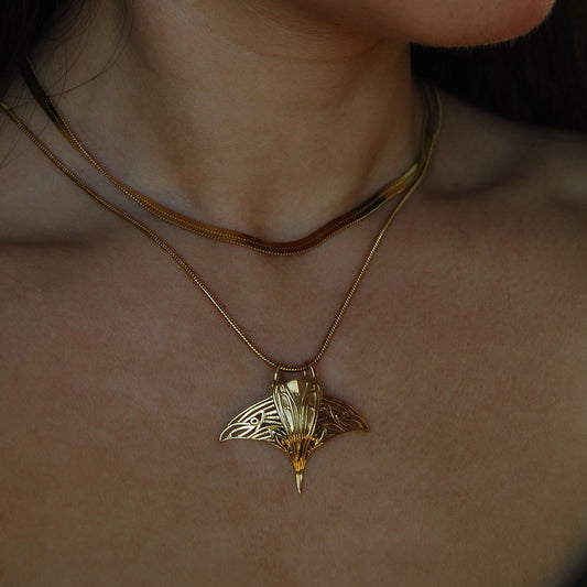 Model wearing gold manta ray pendant necklace, showcasing ocean-inspired jewelry.