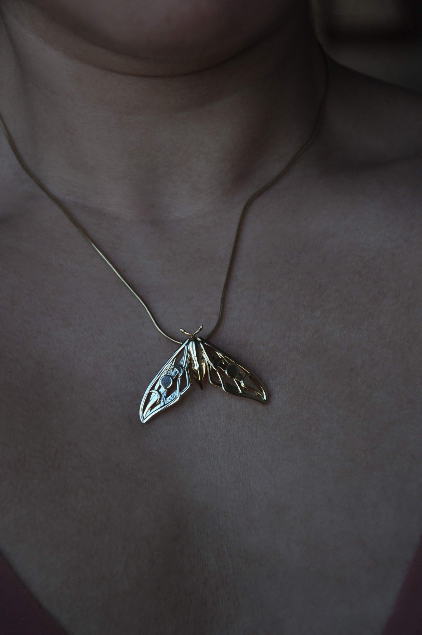 Model wearing the sterling silver Hawk Moth Pendant, illustrating its lightweight elegance and mystical symbolism.