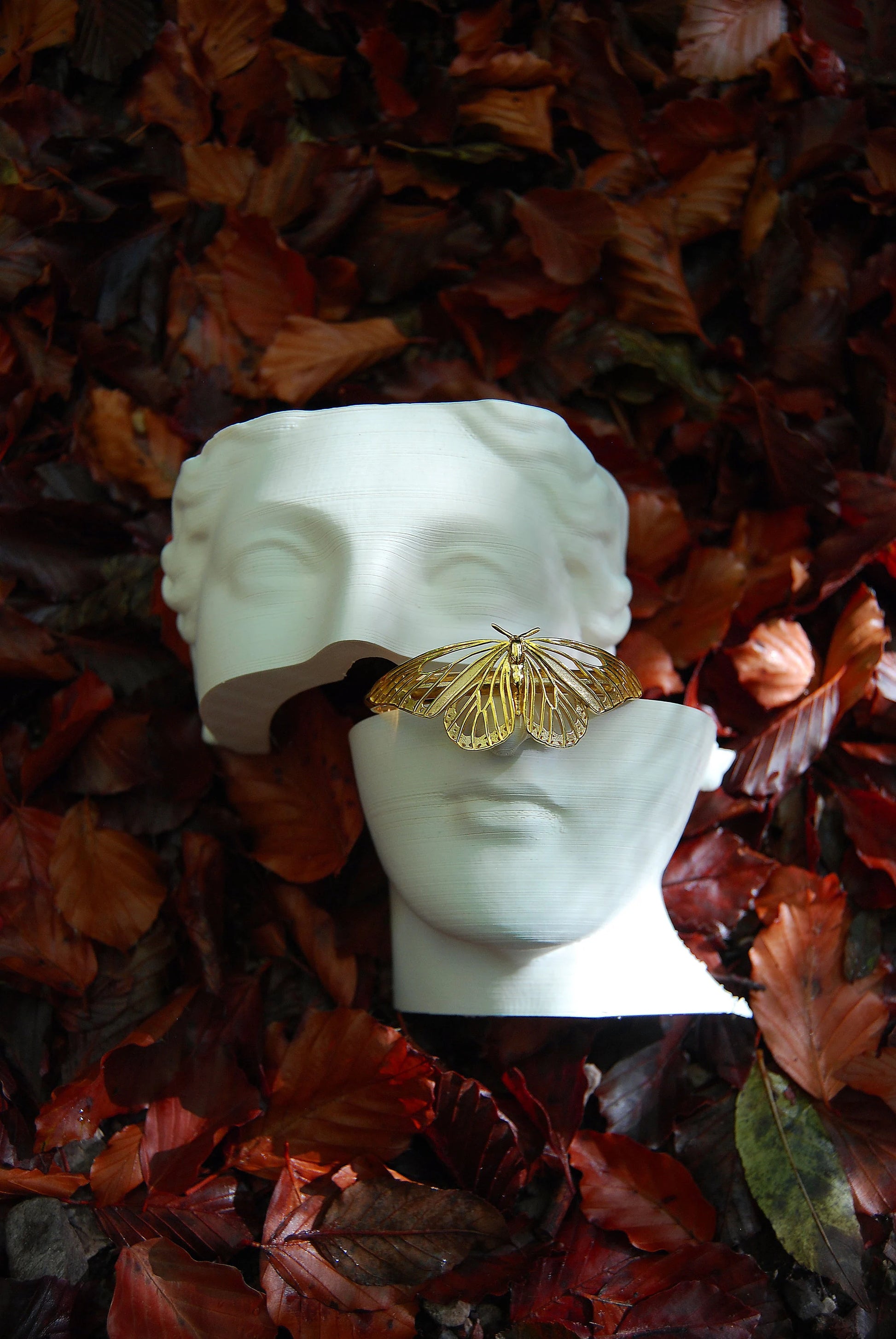 Monarch Butterfly Bracelet displayed on artistic sculpture, emphasizing its organic form and museum-quality craftsmanship.