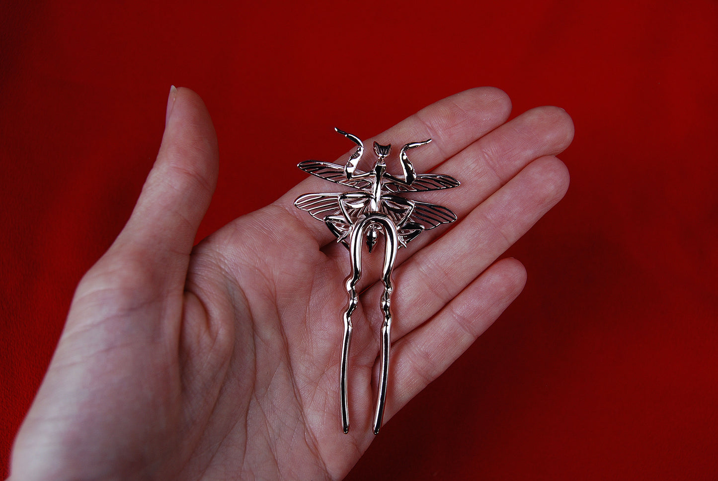 Back view of a handcrafted orchid mantis hair pin