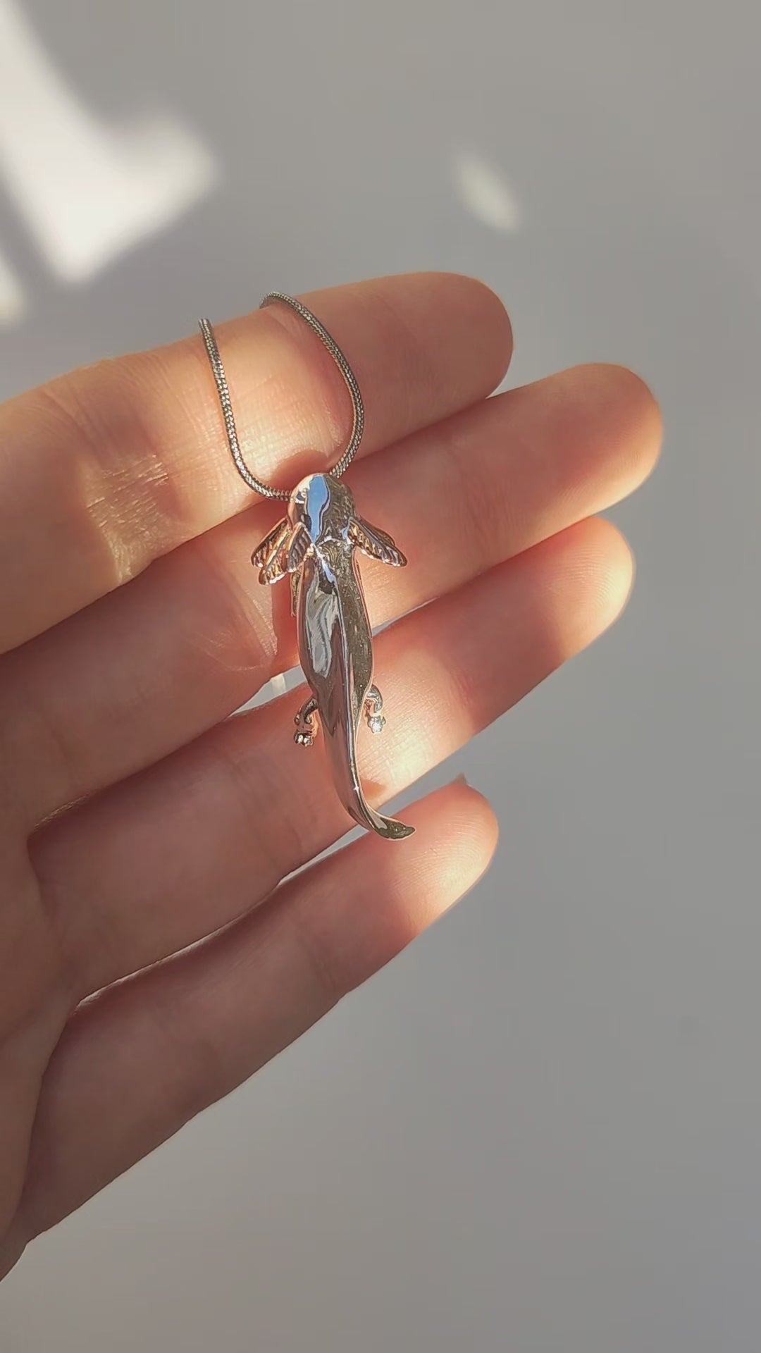 Video showing the Exolotl pendant being held and rotated to display its front and back craftsmanship.