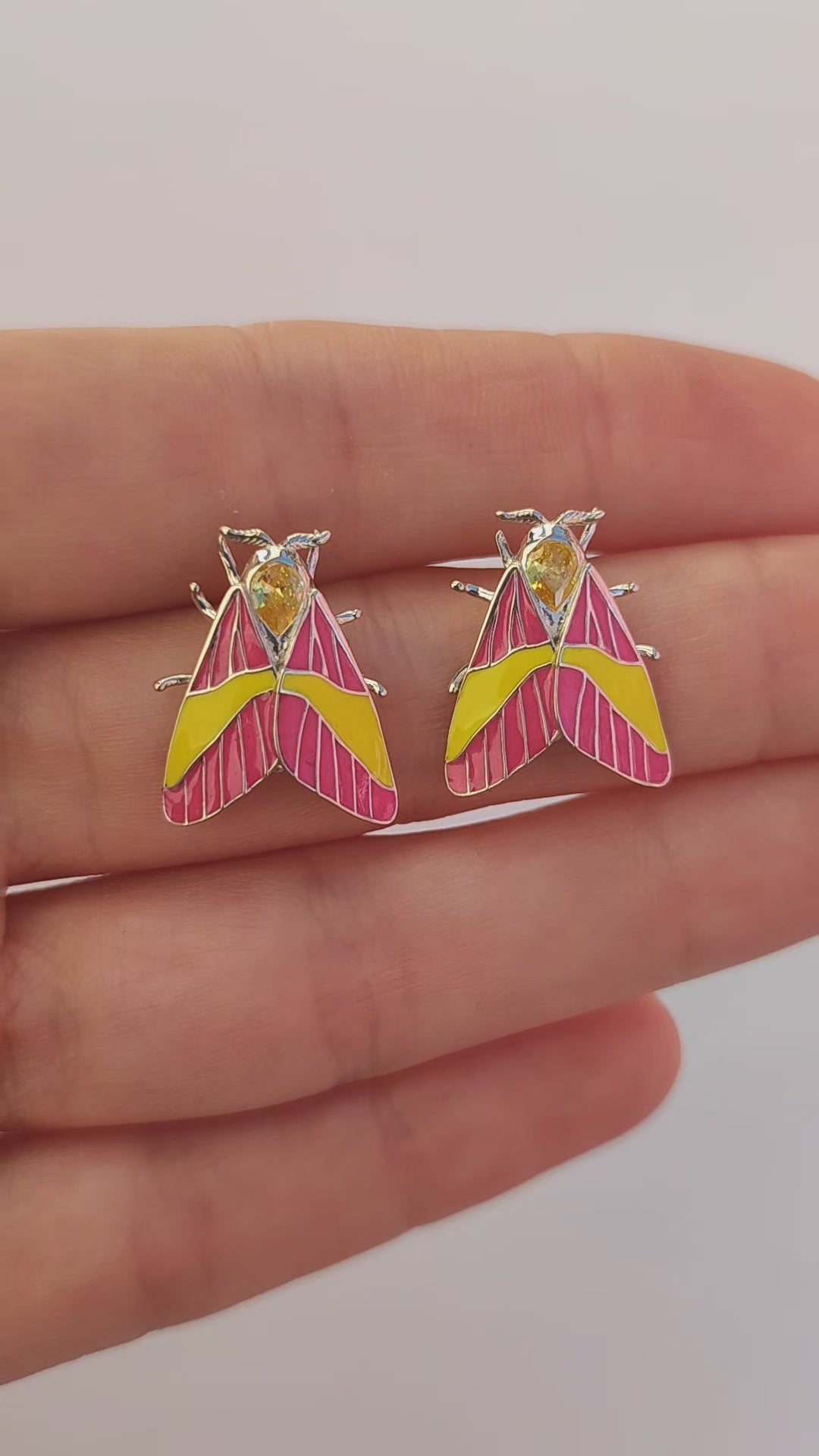 Video of Rosy Maple Moth earrings showing enamel details and gemstone sparkle