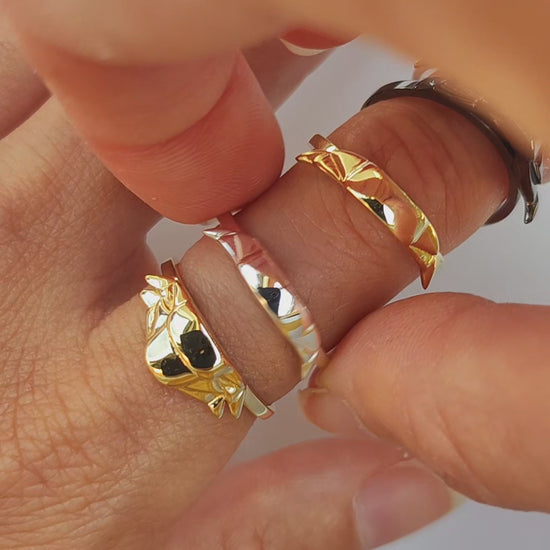 Video showing artisan trilobite stacking rings in mixed rainbow finish being stacked together – handcrafted fossil jewelry with prehistoric ring design.