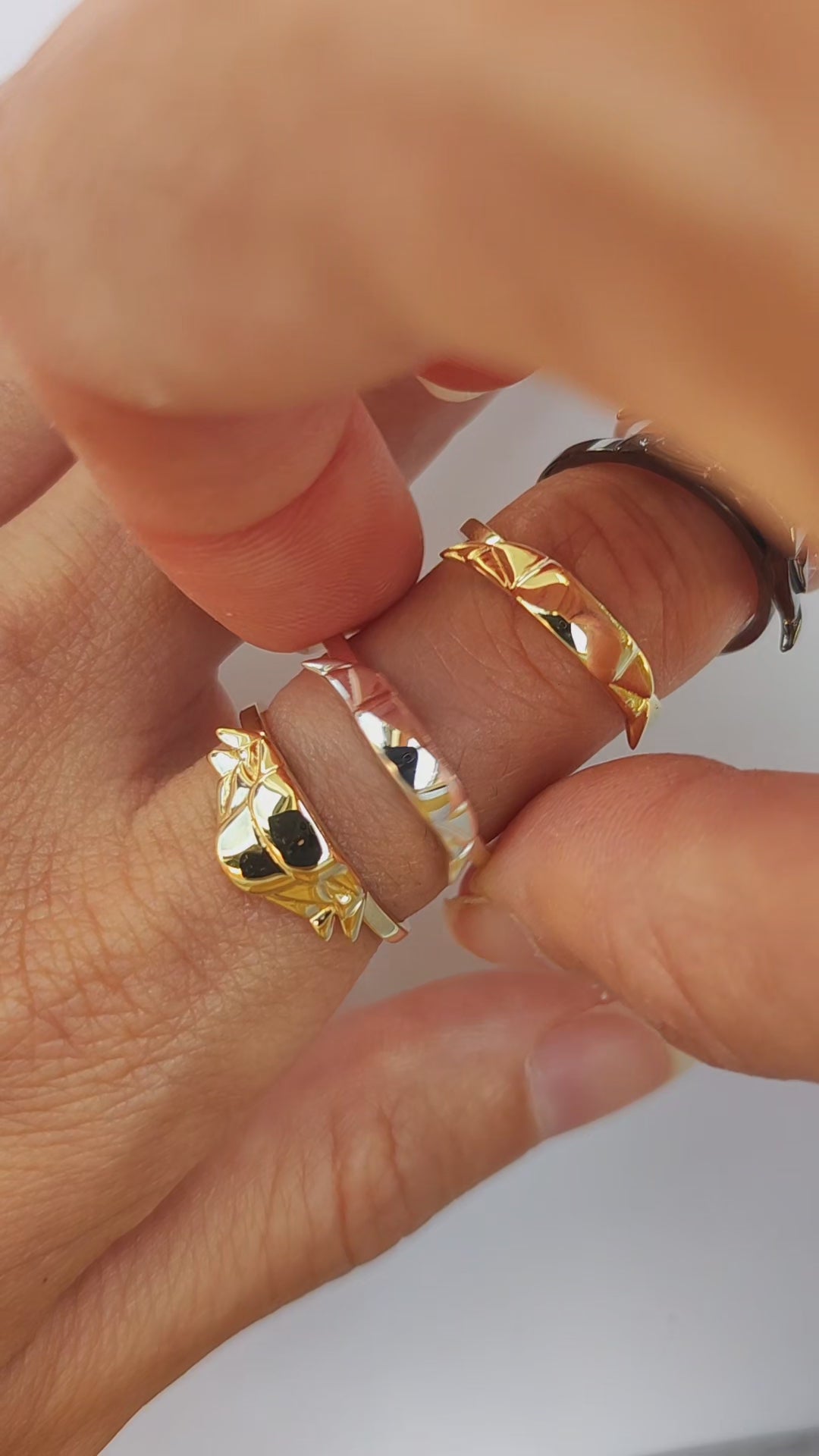 Video showing artisan trilobite stacking rings in mixed rainbow finish being stacked together – handcrafted fossil jewelry with prehistoric ring design.