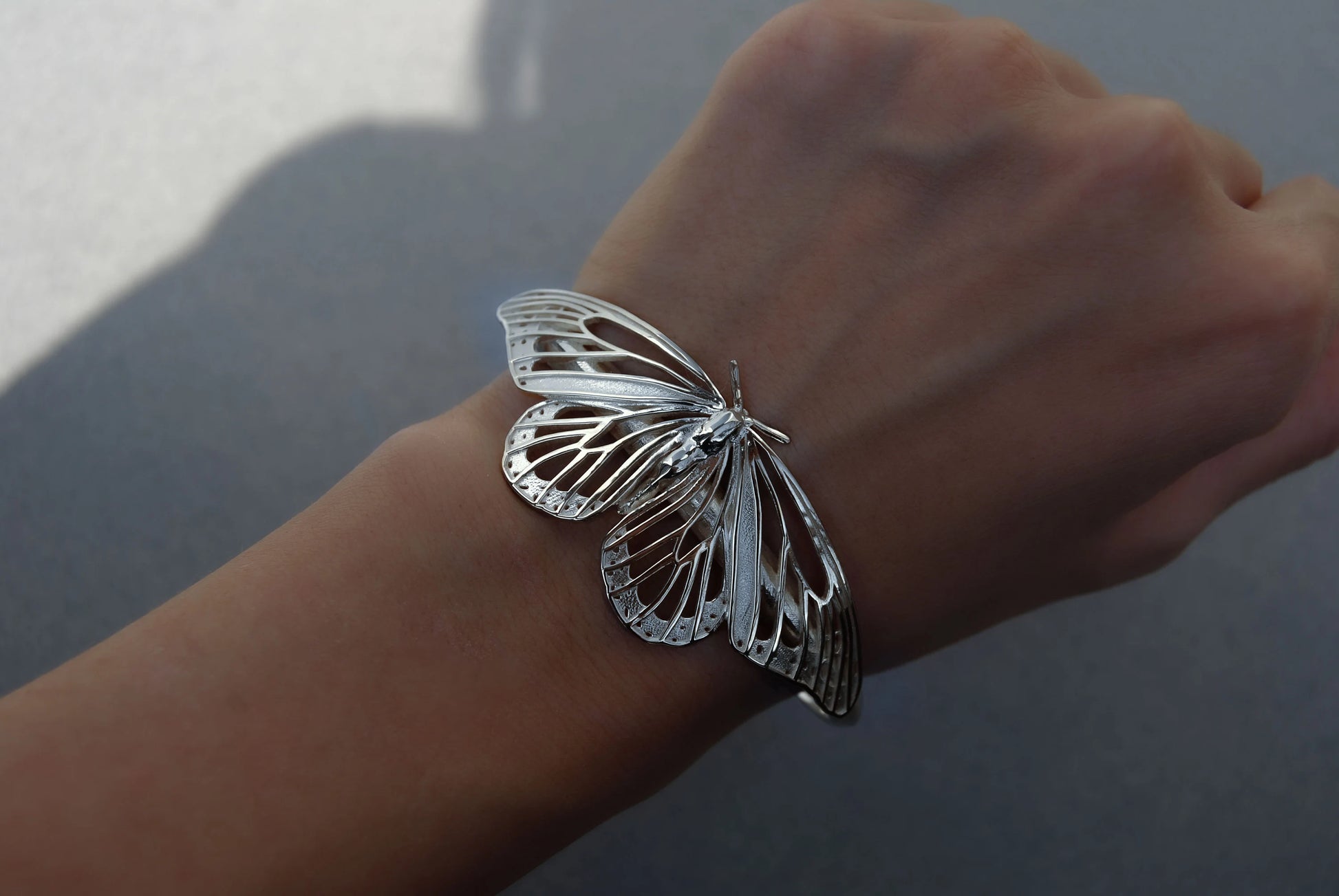 Sterling silver Monarch Butterfly Bracelet displayed on hand, showcasing lightweight design and sculptural wings.