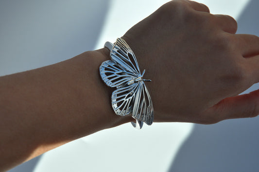 Sterling silver Monarch Butterfly Bracelet worn on hand, showcasing intricate wing cut-outs and nature-inspired design.