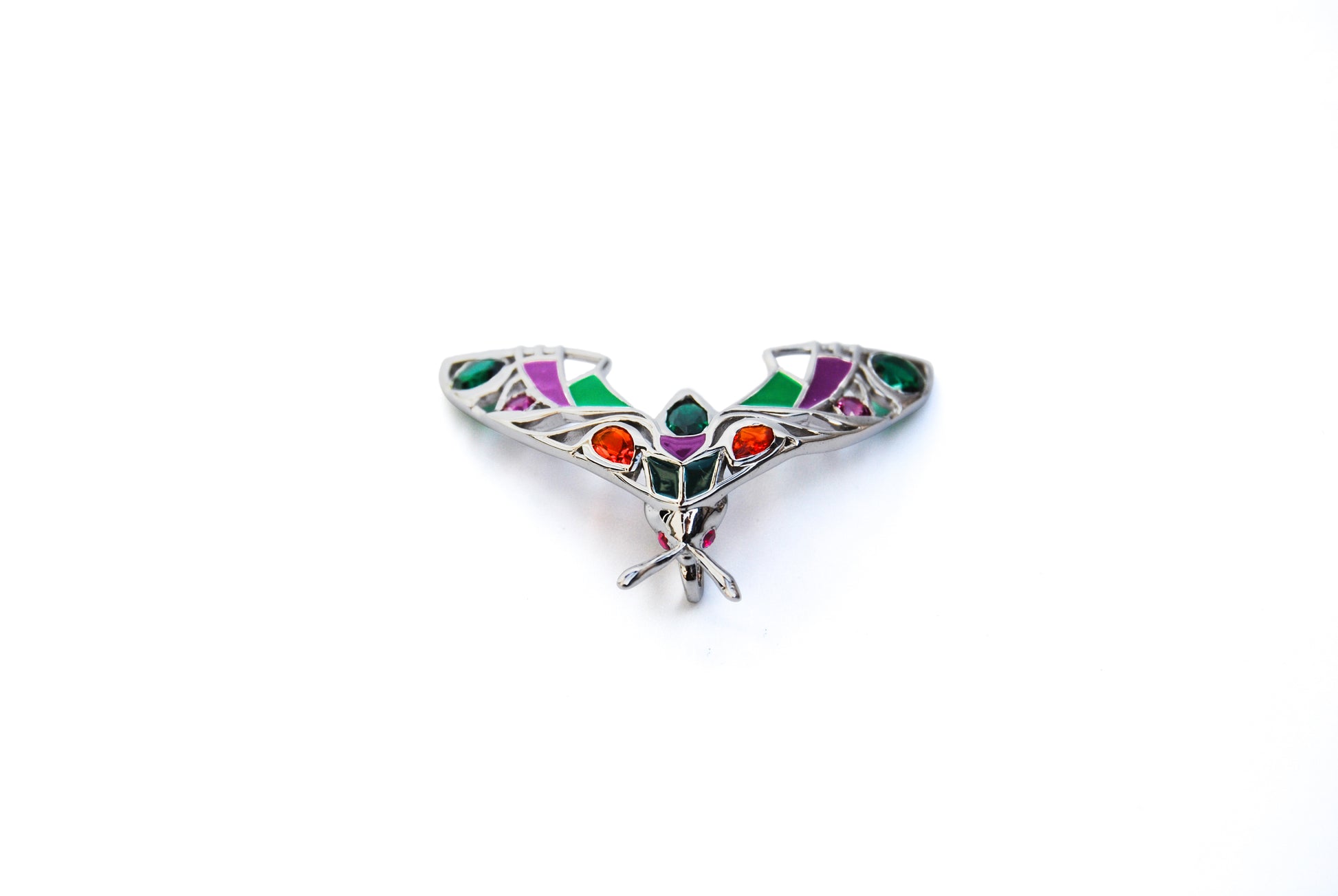 Top view of silver moth pendant necklace on white background