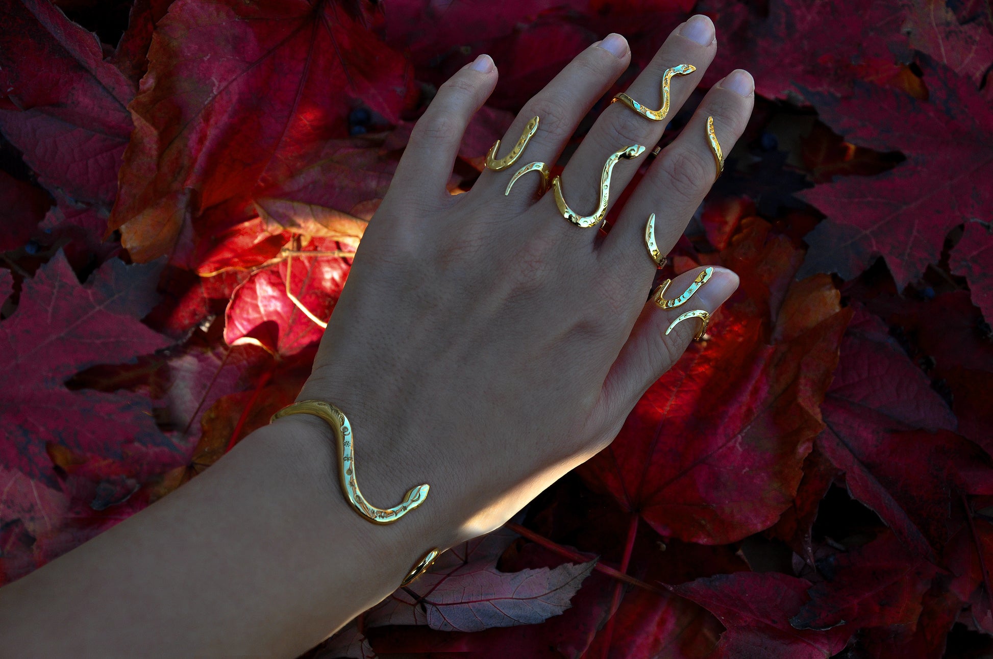 Celestial snake rings stacked with matching bracelet on hand, showcasing symbolic snake jewelry styling.