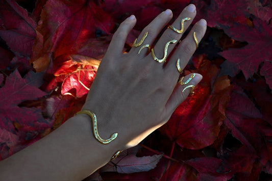 Celestial snake rings stacked with matching bracelet on hand, showcasing symbolic snake jewelry styling.