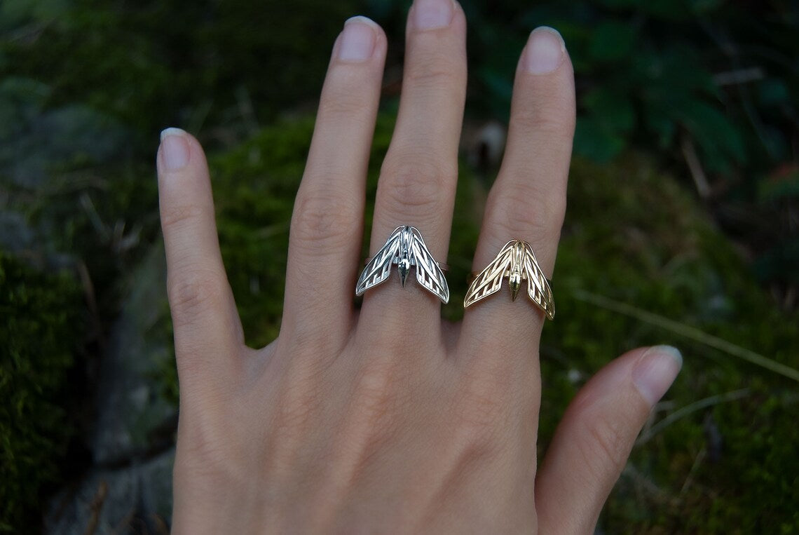 Sphinx moth rings in sterling silver and 14K gold plated finishes worn together on hand, showcasing celestial insect jewelry.